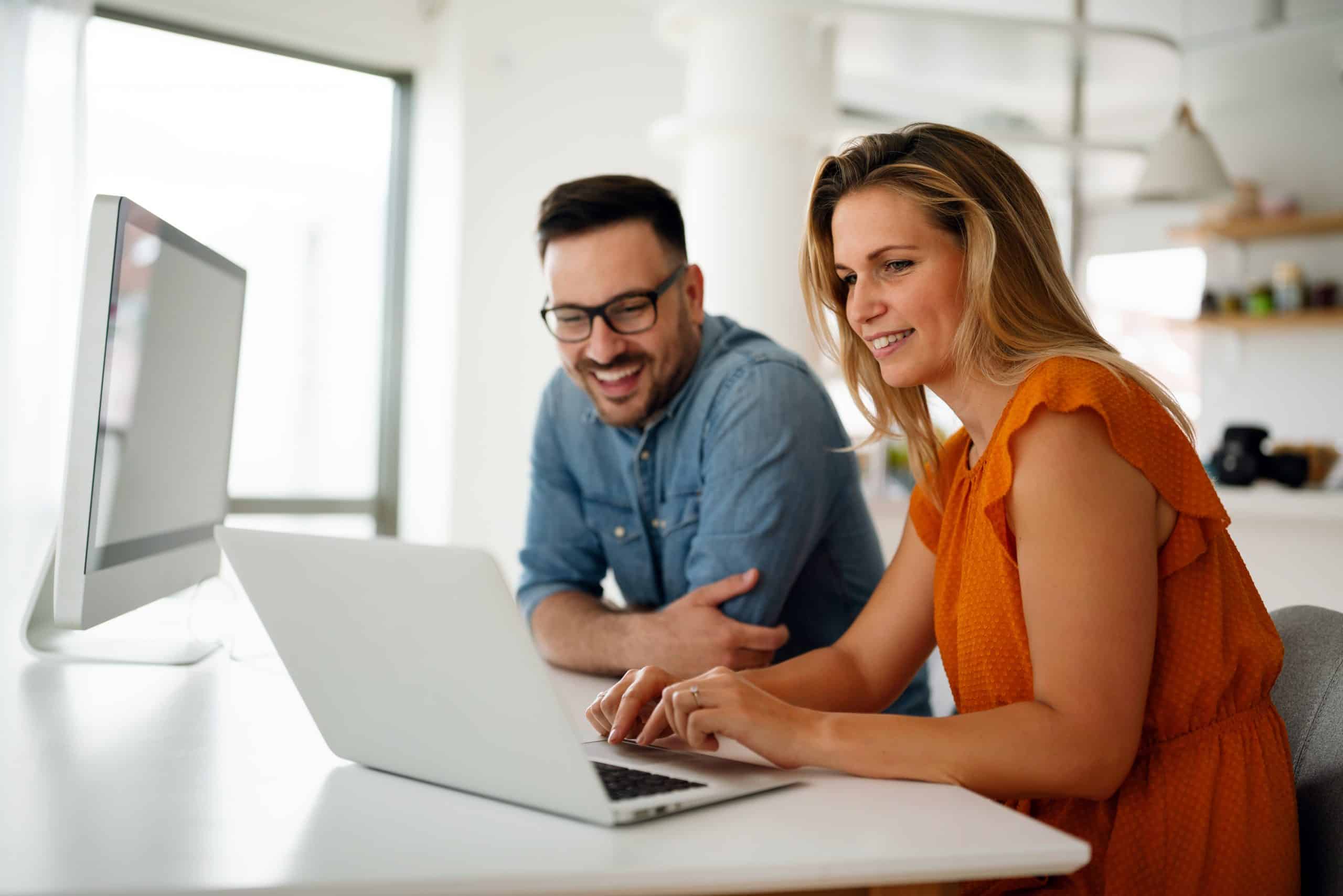 coppia sorridente davanti laptop felice dei risultati del growth marketing